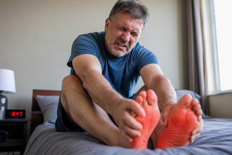 Man with burning feet trying to soothe them